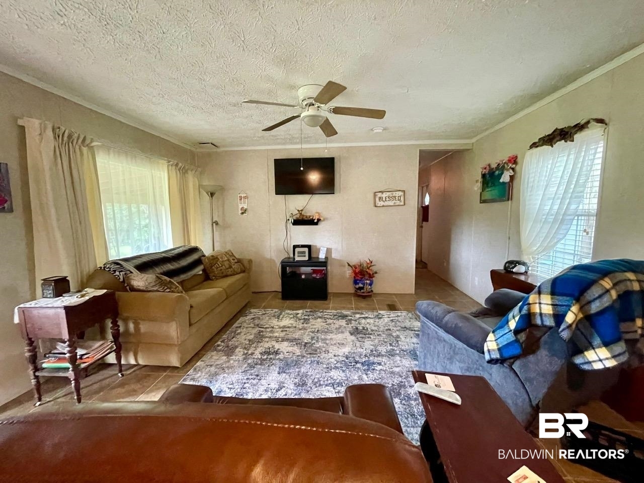 15338 Windbigler Drive Foley, AL 36535 - Photo 7 of 28 Living room with ceiling fan, ornamental molding, a textured ceiling, and tile patterned flooring