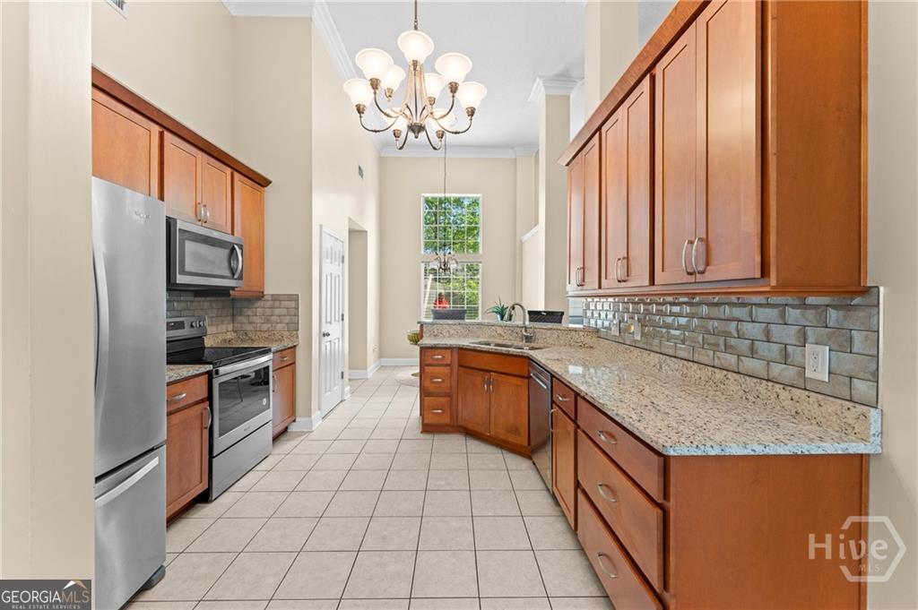 10 Fox Hound Court Pooler, GA 31322 - Photo 14 of 32 a large kitchen with stainless steel appliances granite countertop a sink and dishwasher a refrigerator with wooden cabinets