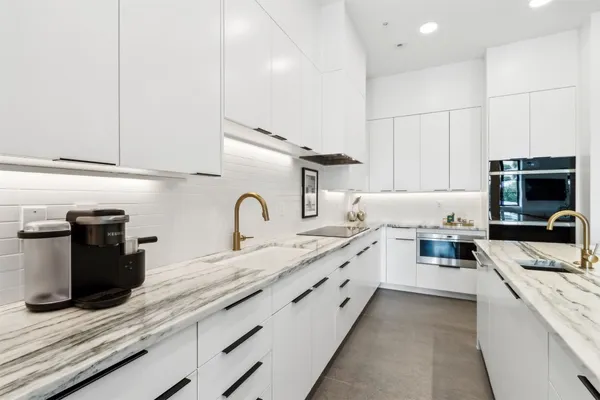 a large kitchen with granite countertop a sink and a stove