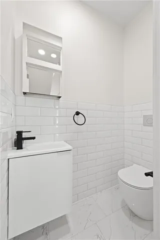 a bathroom with a toilet a sink and mirror