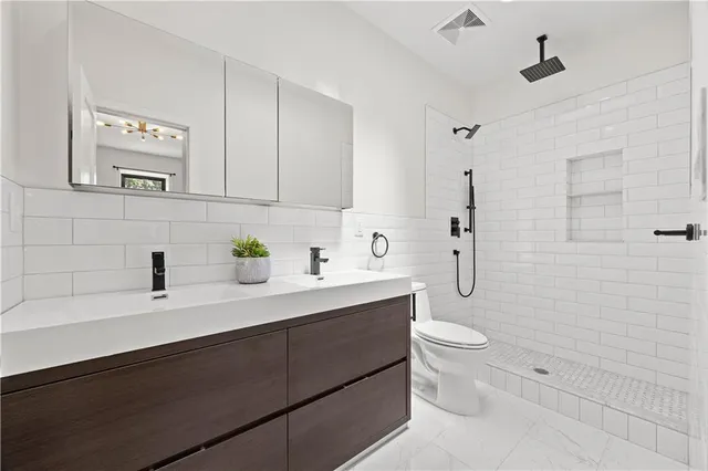 a bathroom with a sink a toilet and shower