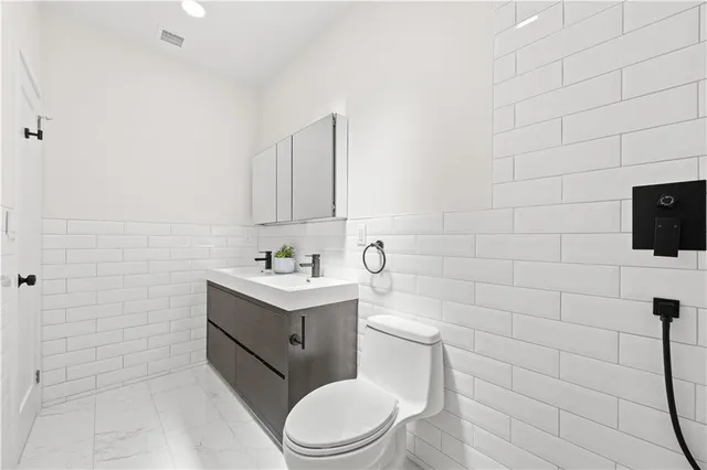 a bathroom with a toilet sink and mirror