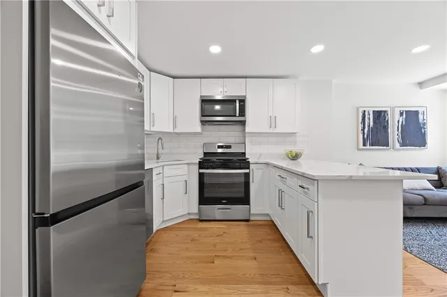 a kitchen with white cabinets and stainless steel appliances