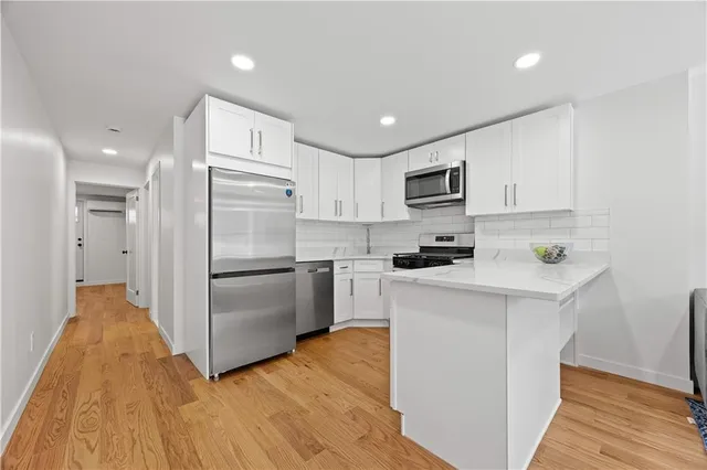 a kitchen with granite countertop a refrigerator and a stove top oven