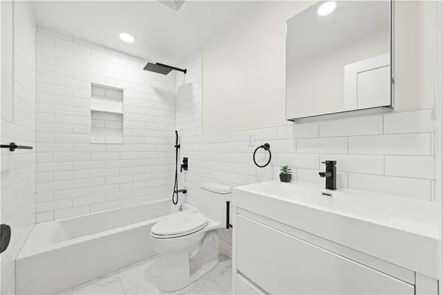 a bathroom with a toilet a sink a mirror and shower