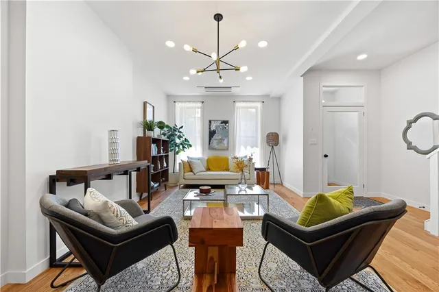 a living room with furniture a chandelier and a rug