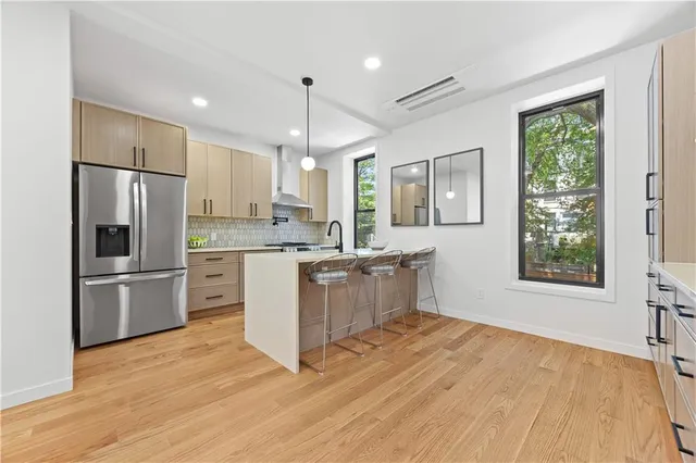 a kitchen with a refrigerator a stove a sink cabinets and wooden floor