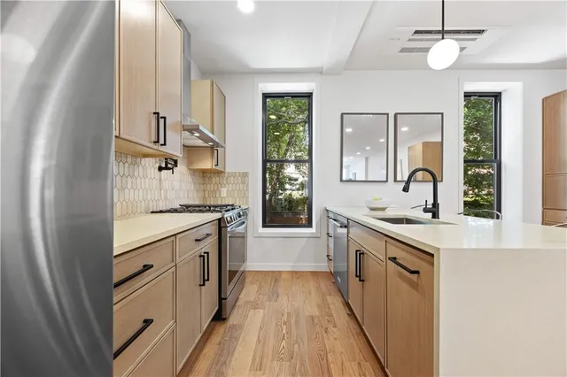 a kitchen with granite countertop a sink stove and refrigerator