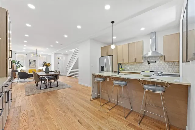 a kitchen with stainless steel appliances kitchen island granite countertop a table chairs sink and cabinets