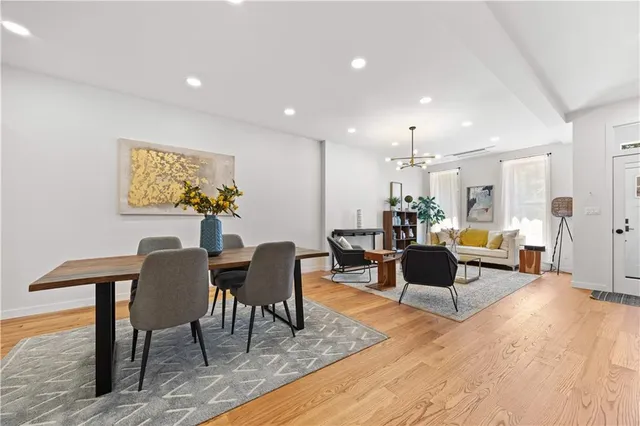 a living room with furniture and a dining table with wooden floor