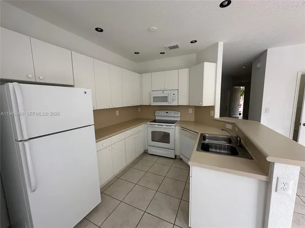 a kitchen with a stove a sink and a refrigerator