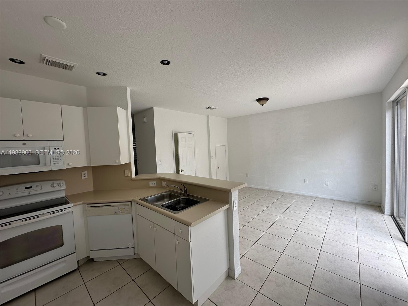 16602 Southwest 78th Terrace Miami, FL 33193 - Photo 17 of 18 a kitchen with a stove a sink and a refrigerator