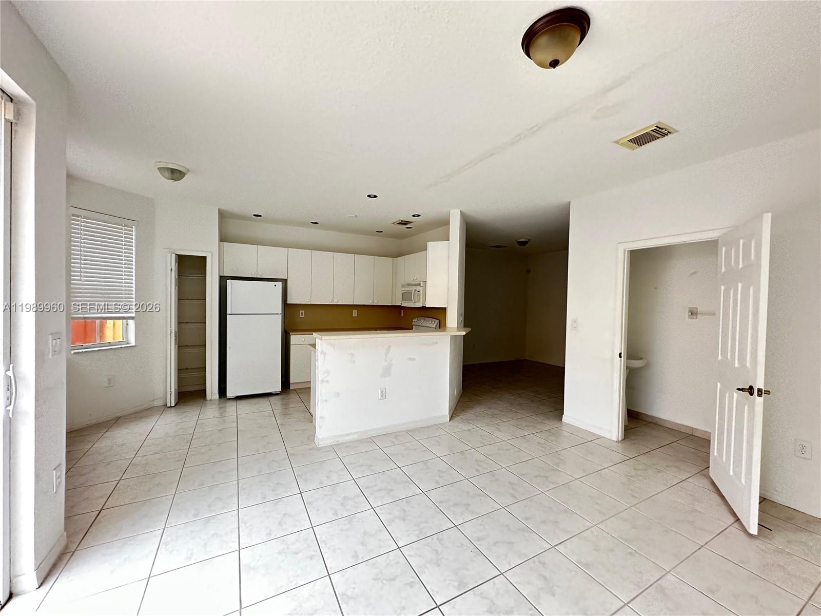 16602 Southwest 78th Terrace Miami, FL 33193 - Photo 3 of 18 an empty room & kitchen view with an empty space