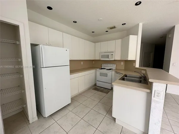 a kitchen with a refrigerator sink stove and cabinets