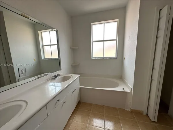 a bathroom with a tub sink and mirror