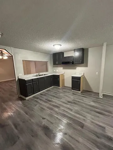 a large kitchen with kitchen island a stove a sink and a microwave