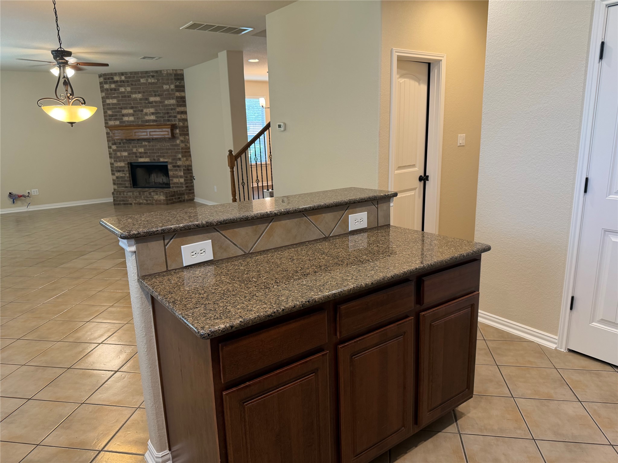 3021 Grand Mission Way Pflugerville, TX 78660 - Photo 15 of 31 A functional kitchen island anchors this open-concept space, offering granite countertops and rich cabinetry.