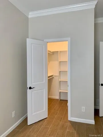a view of an empty room with closet and a window