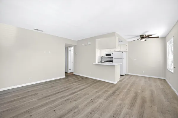 wooden floor in an empty room with a kitchen
