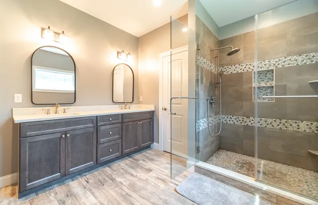 a bathroom with a double vanity sink mirror and shower