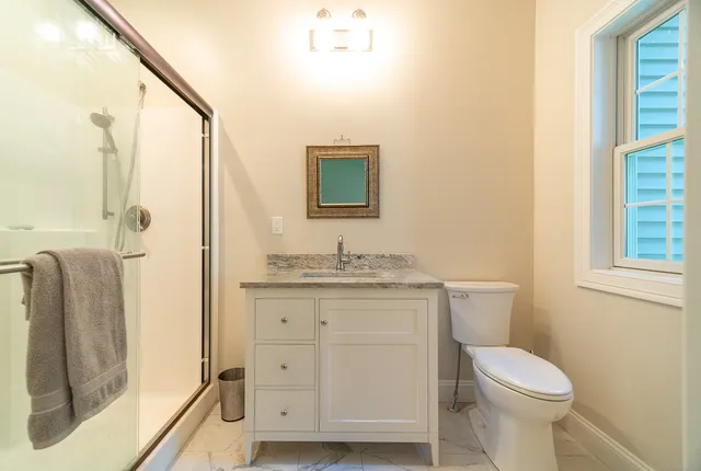a bathroom with a granite countertop toilet sink and a mirror