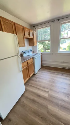 a kitchen with window wooden floor and electronic appliances