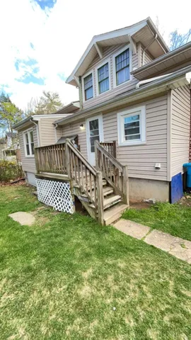 a view of a house with a yard and deck