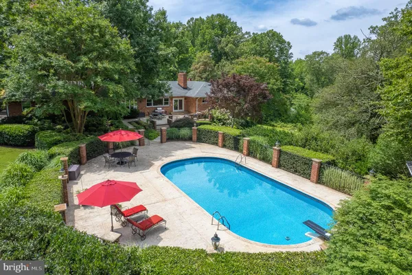 an aerial view of residential house with outdoor space and trees all around