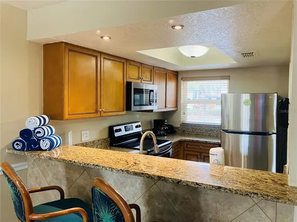 a kitchen with stainless steel appliances granite countertop a sink refrigerator and microwave