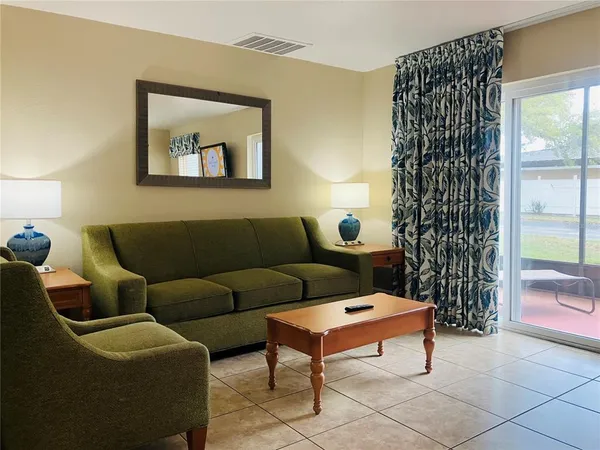 a living room with furniture and a potted plant