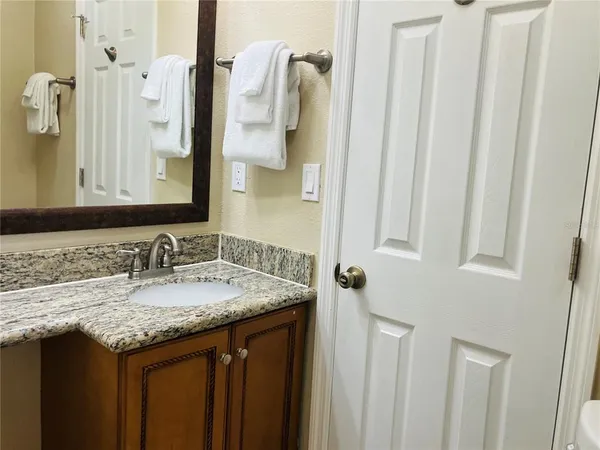 a bathroom with a granite countertop sink and a mirror