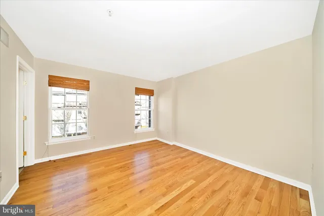 an empty room with windows and closet