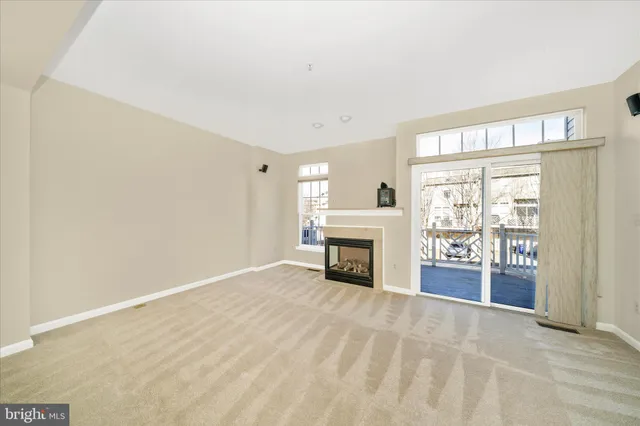 a view of an empty room with a fireplace and a window