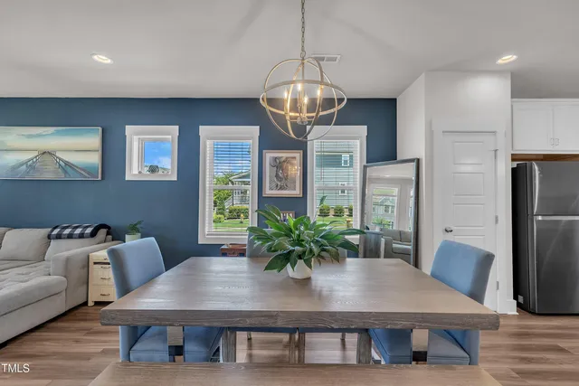 a kitchen with stainless steel appliances granite countertop a stove top oven a sink a dining table and chairs