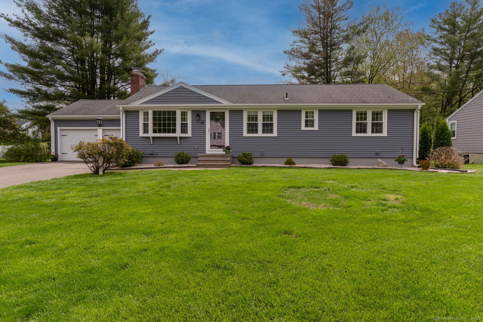 a front view of a house with a yard and trees