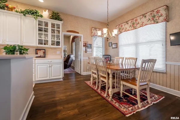 a kitchen with a sink window and white cabinets