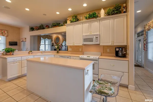 a living room with kitchen island furniture and a view of kitchen
