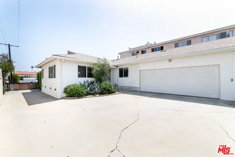 a view of a white house with a yard and garage