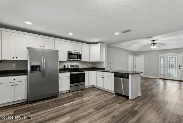 a kitchen with granite countertop stainless steel appliances and wooden cabinets