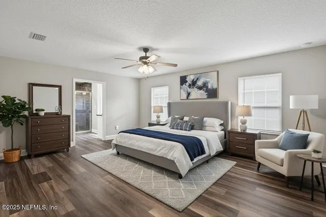 a spacious bedroom with a bed and wooden floor