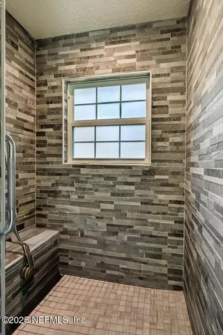 a bathroom with a shower and a window