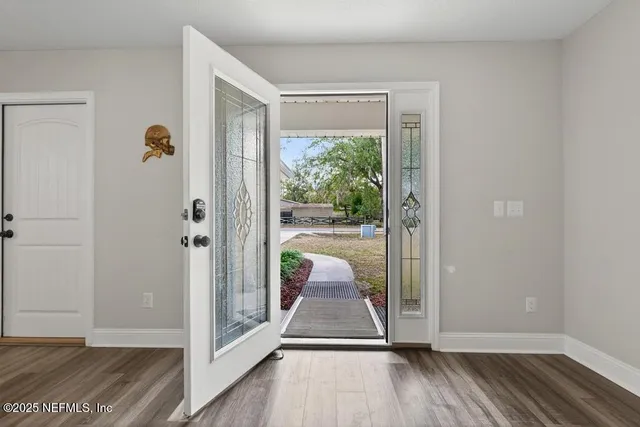 a view of a hallway with wooden floor and glass door