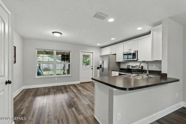 a kitchen with sink a window and appliances