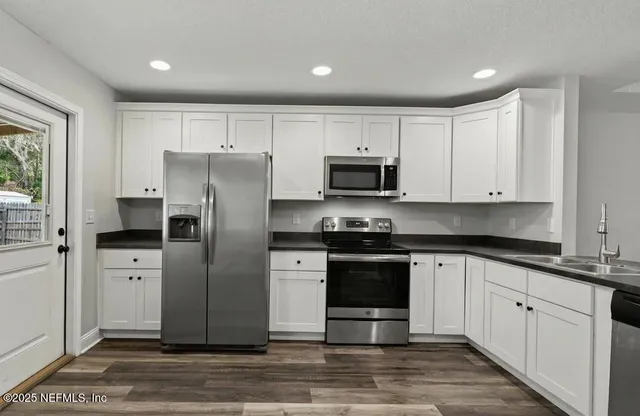 a kitchen with stainless steel appliances granite countertop a refrigerator and a stove top oven