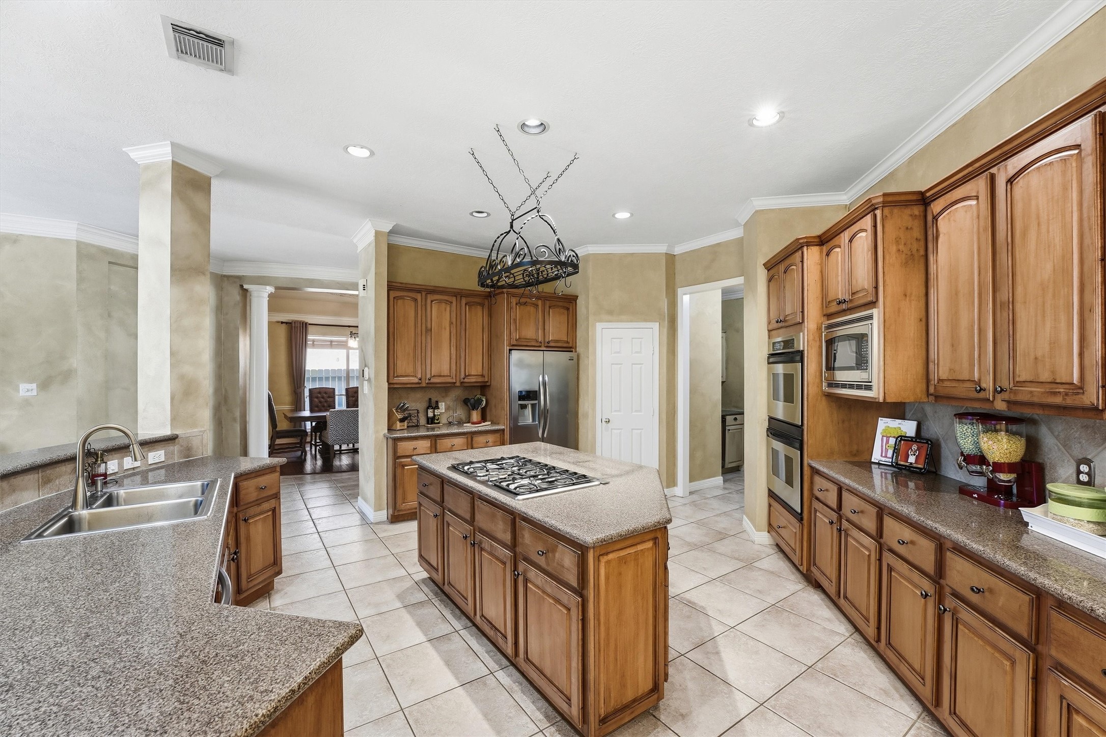 7303 Texas Laurel Loop Humble, TX 77346 - Photo 11 of 32 a kitchen with stainless steel appliances granite countertop a stove a sink and a refrigerator