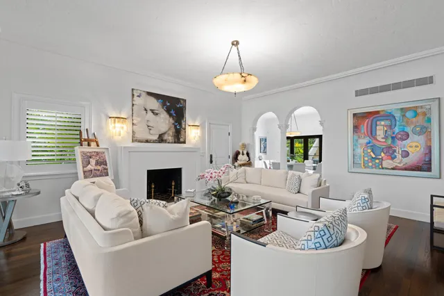 a living room with furniture chandelier and a fireplace