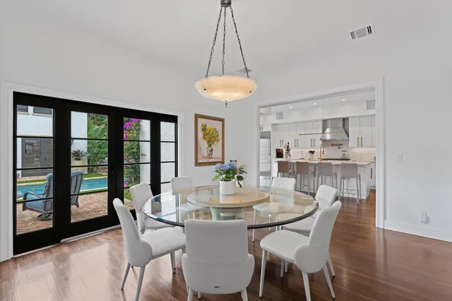 a dining room with furniture a chandelier and wooden floor