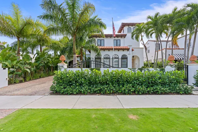 a view of a house with a yard and potted plants