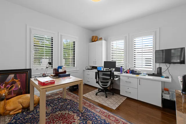 a room with furniture a rug a workspace and a window