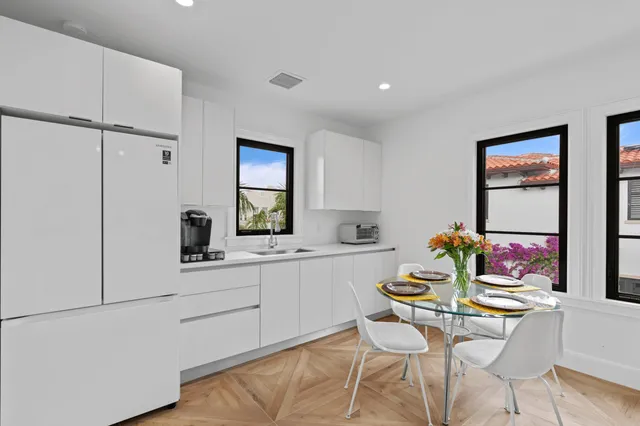 a kitchen with a dining table chairs and white stainless steel appliances